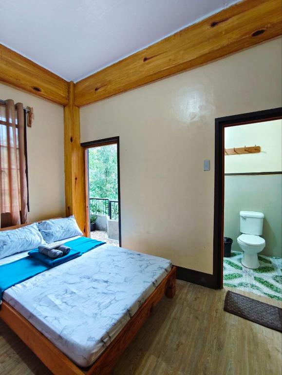 a bedroom with a large bed and a toilet at Sagada Staycation with Mountain View! in Sagada