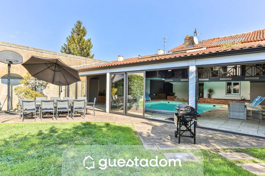 a house with a patio and a swimming pool at L'atypique - Piscine intérieure - Wifi in Challans