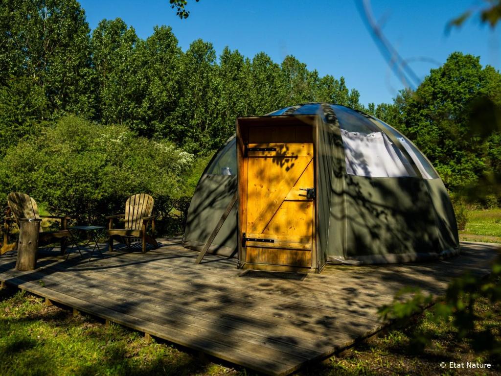 a yurt with a yellow door on a wooden deck at Bulle nuage - Etat Nature in Magnières