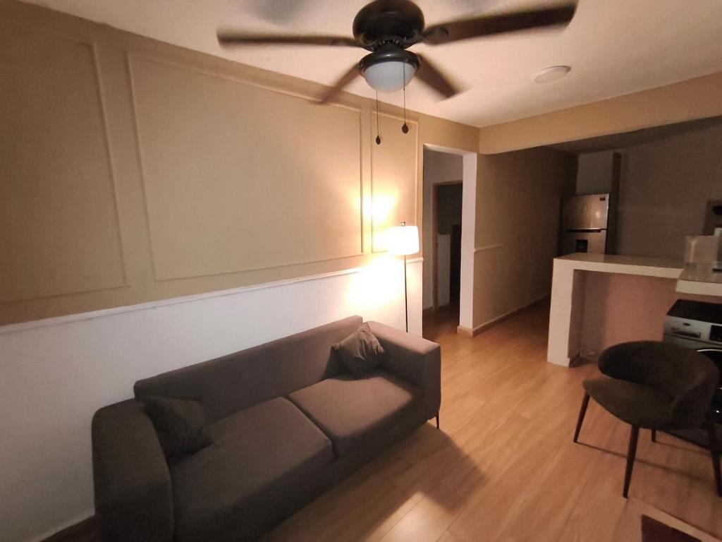 a living room with a couch and a ceiling fan at Quiet place in El Seis