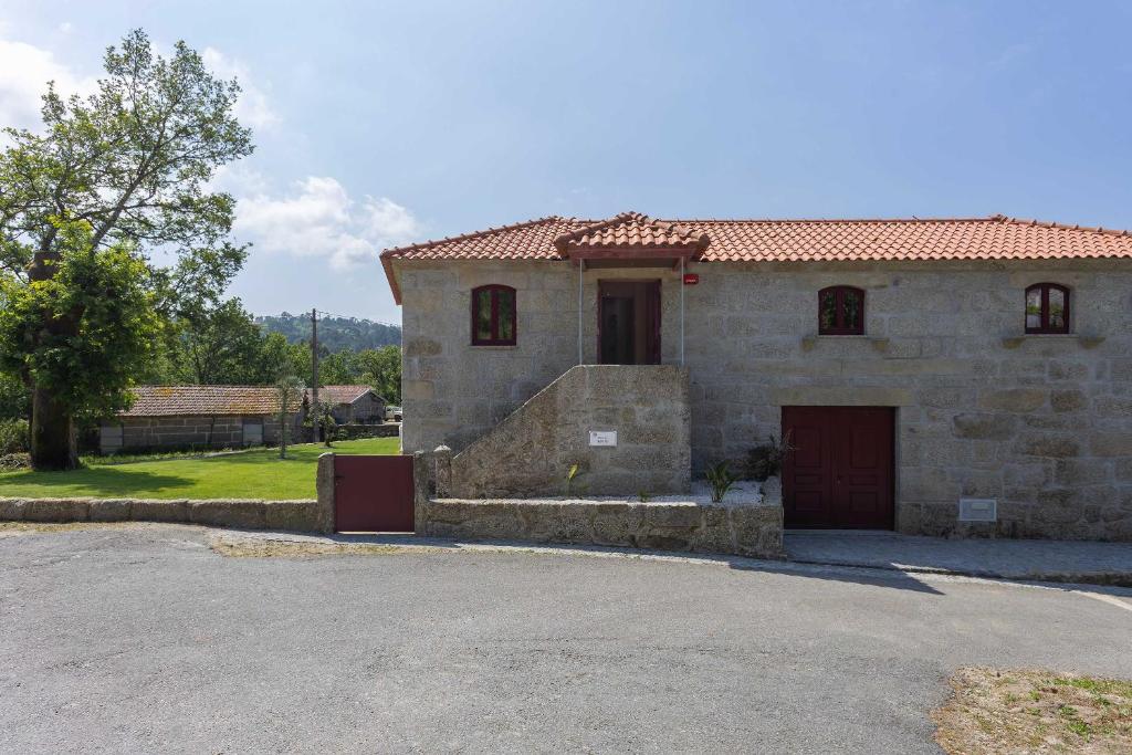 a stone house with a driveway in front of it at Casas do Bacelar by Liiiving in Quinchães