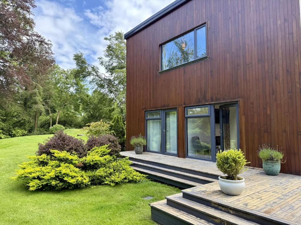 a wooden house with a deck in a yard at Property 525 - Galway in Moycullen