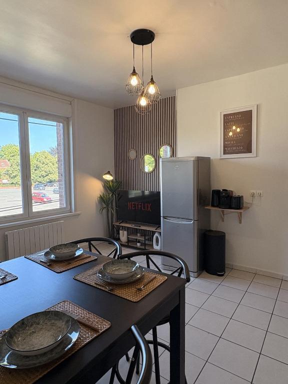 a kitchen with a table and a refrigerator at Le COCON centre de Bethune in Béthune