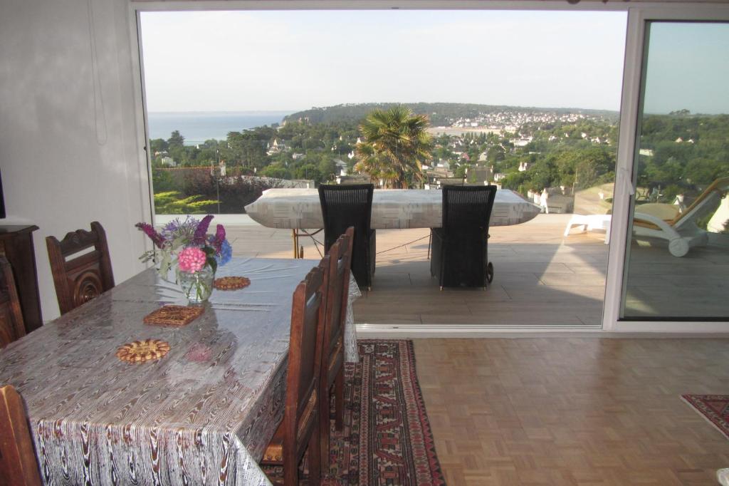 a dining table with a view of the ocean at Maison avec vue sur Morgat in Crozon