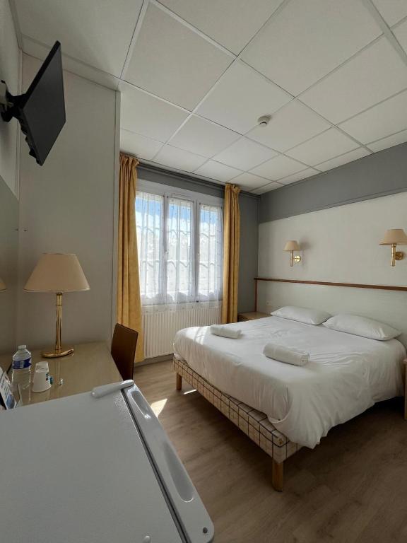 a bedroom with a large bed and a television at Hotel De La Mer in La Tranche-sur-Mer