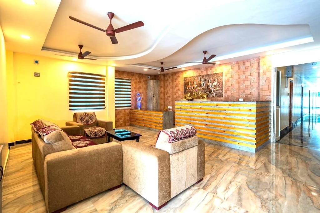 a living room with two couches and a ceiling fan at Sunlux Villa in Pondicherry