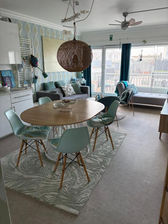 a kitchen and living room with a table and chairs at Ma Mère Beach Condo Oostende in Ostend