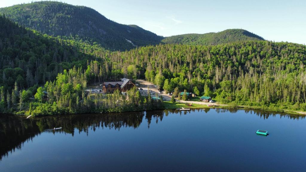 an island in the middle of a lake with a house at Auberge Boréale de Charlevoix in Petit-Saguenay