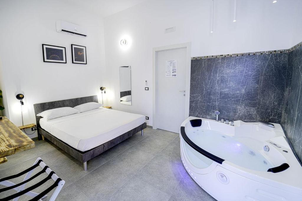a bedroom with a bed and a tub next to a bed at SEASIDE TWINS b&b in Fragagnano