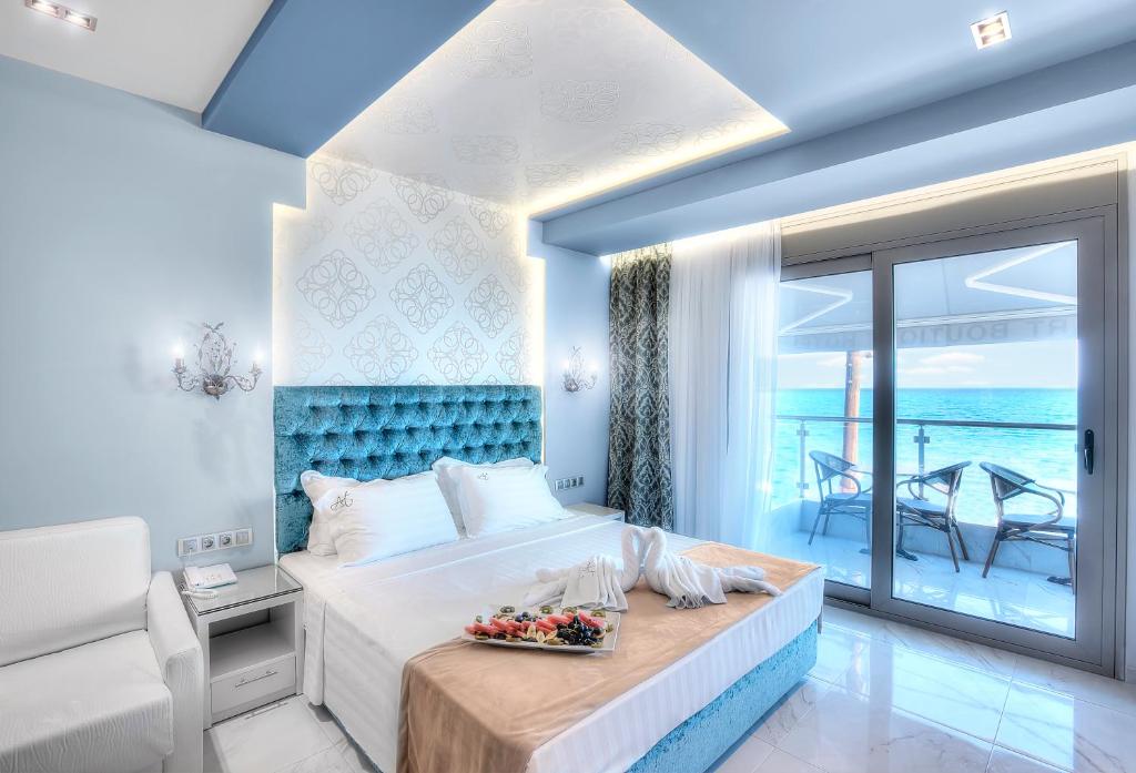 a bedroom with a large bed with a view of the ocean at Art Boutique Suites in Pefkochori