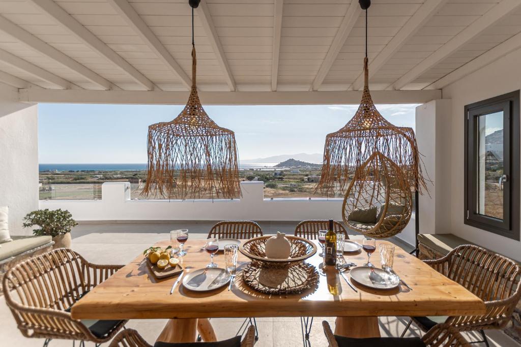a dining room with a table and chairs and chandeliers at Naxian Pearl in Mikri Vigla