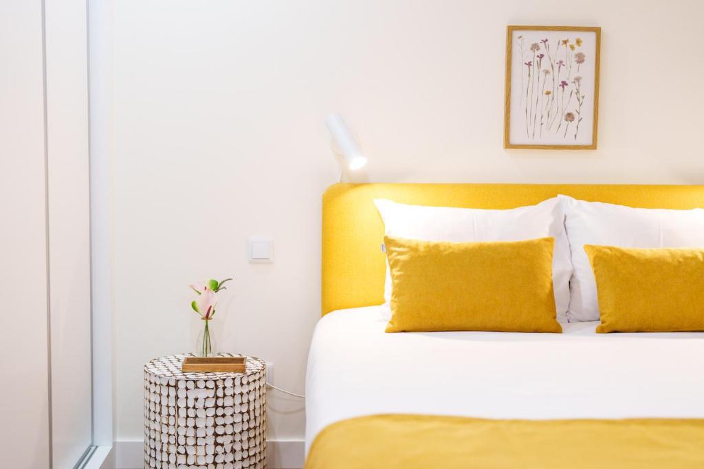 a bedroom with a bed with yellow pillows at Casa Amarela do Redondo in Seixal