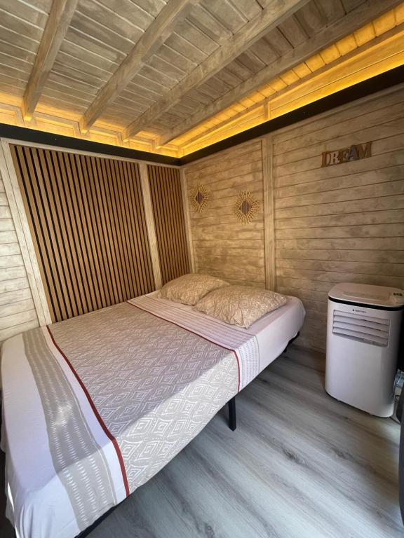 a bed in a room with a wooden wall at Cabane insolite avec jacuzzi in Menton