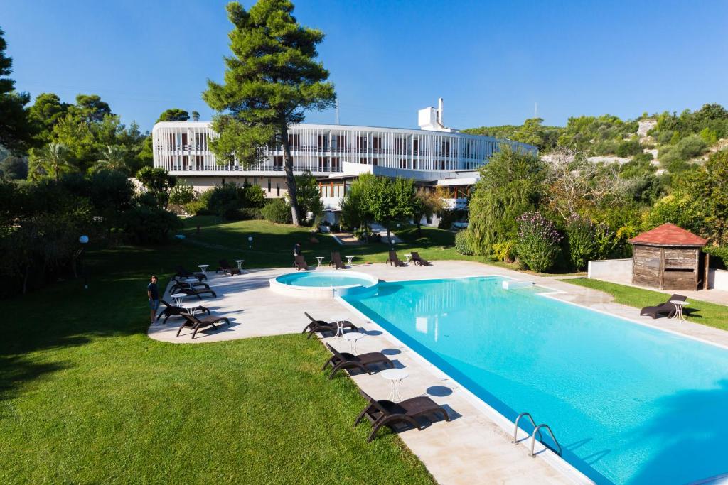 einen Blick über einen Pool mit Stühlen und ein Gebäude in der Unterkunft Valtur Baia del Gusmay Beach Resort in Peschici