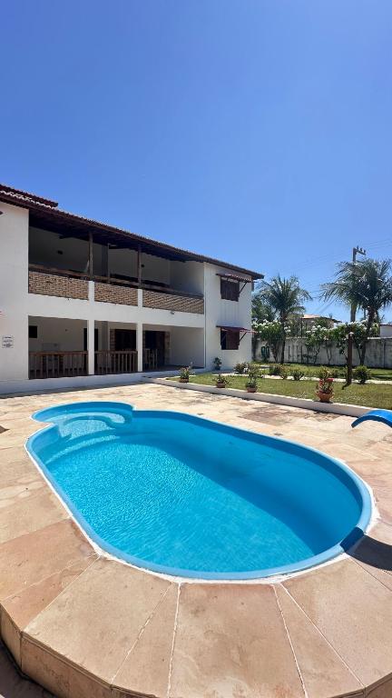 a large blue swimming pool in front of a building at Apartamentos da Jangada in Canoa Quebrada