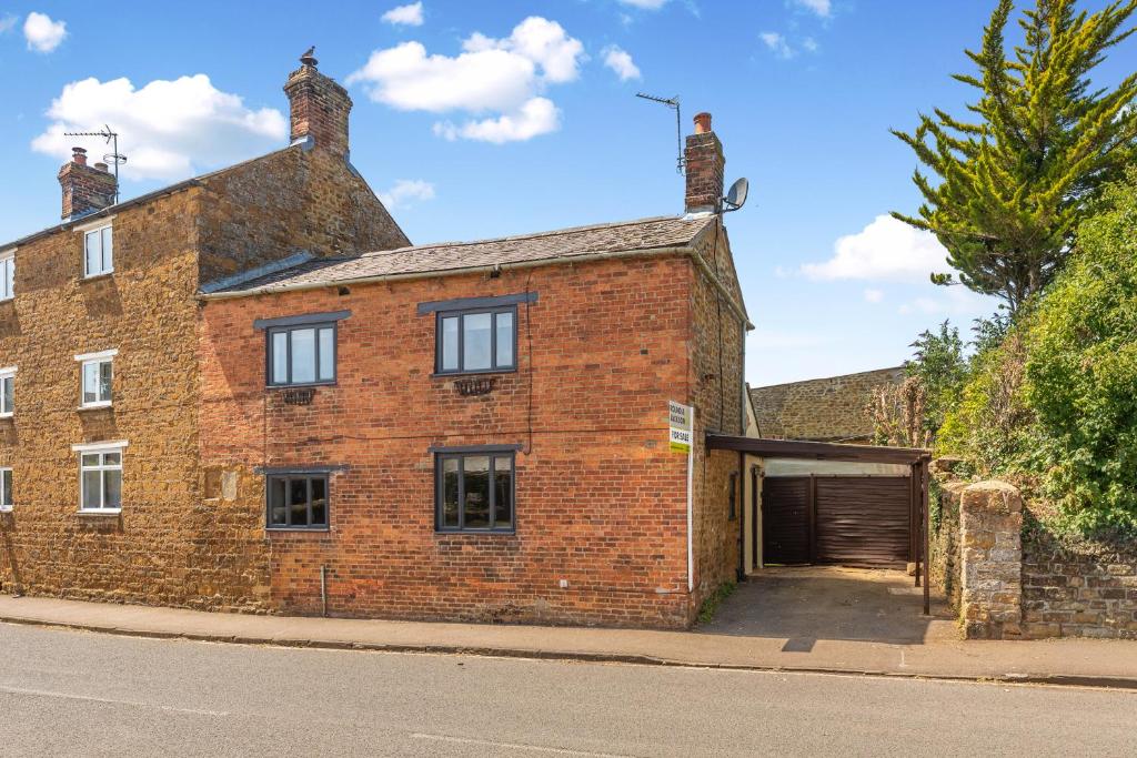 an old brick building with a garage on a street at Malvern House in Banbury