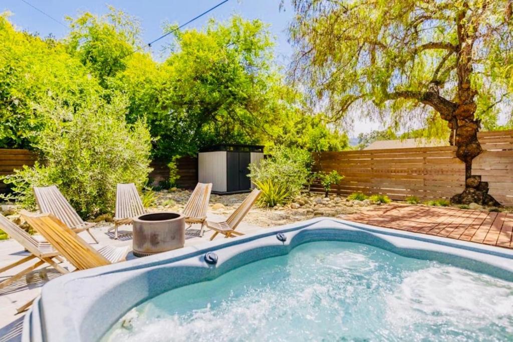 a swimming pool in a yard with chairs and a fence at Downtown Ojai Gem in Ojai