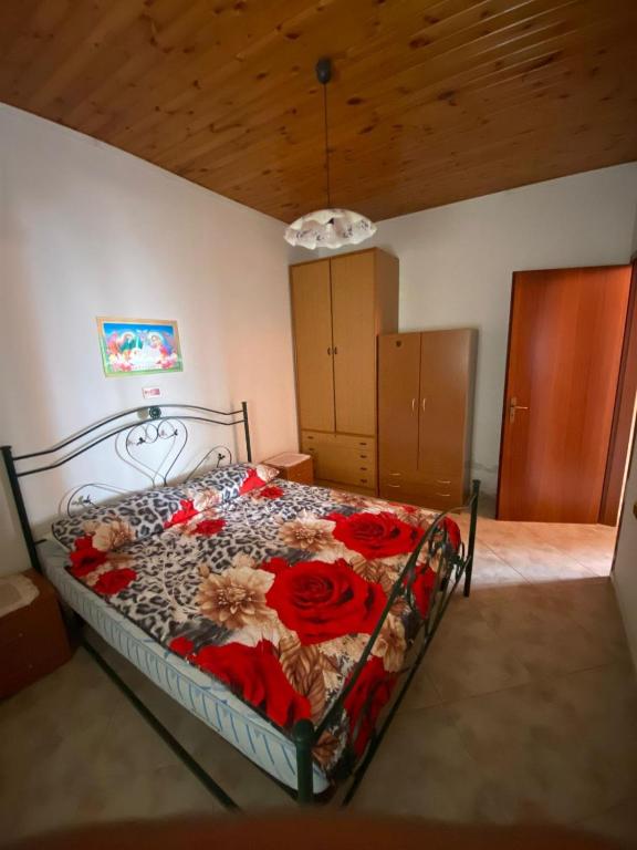 a bedroom with a bed with red flowers on it at B&B da Alessandro in Palmi