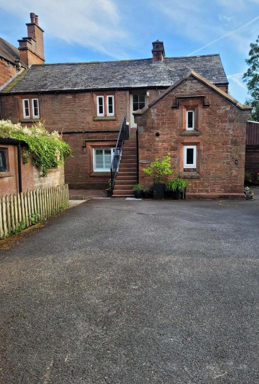 an old brick house with a driveway in front of it at Brent Top in Penrith