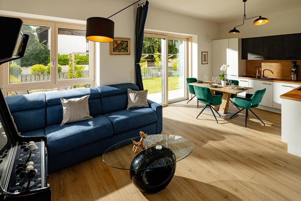 a living room with a blue couch and a kitchen at Rauchhof Apartments in Auer