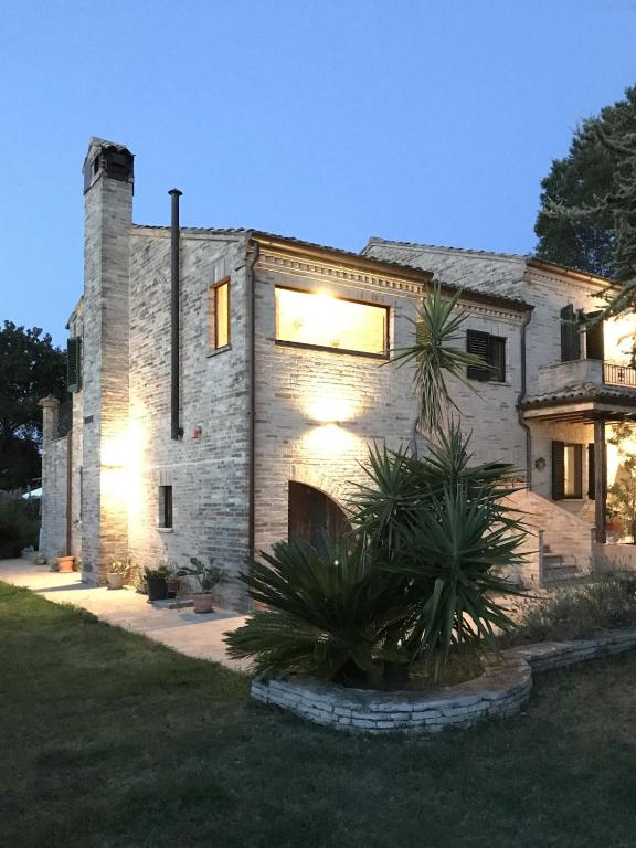 a stone house with a tree in front of it at Casa Olivi, Fermo in Fermo