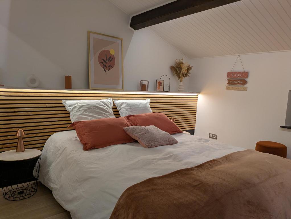 a bedroom with a bed with two pillows on it at Charmant Cocon, terrasse proche Clermont in Tallende