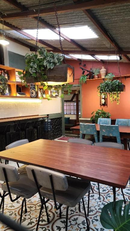 a table and chairs in a room with plants at SEMERU HOSTEL MALANG in Malang