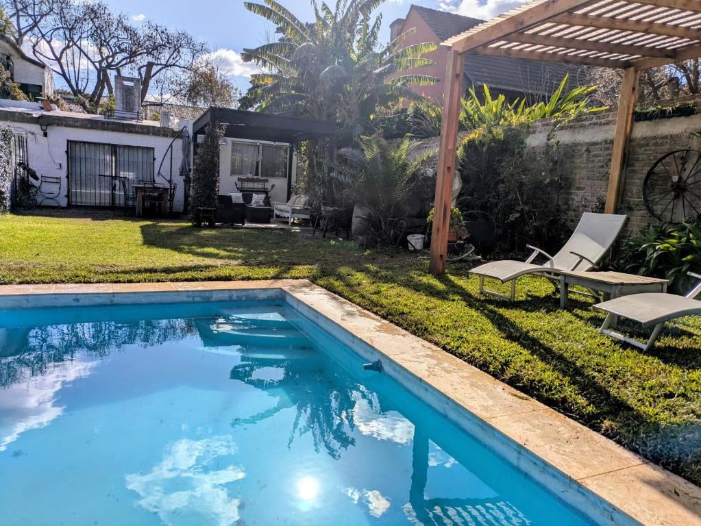 a swimming pool in a backyard with a pergola at A estrenar, en San Isidro. in Beccar