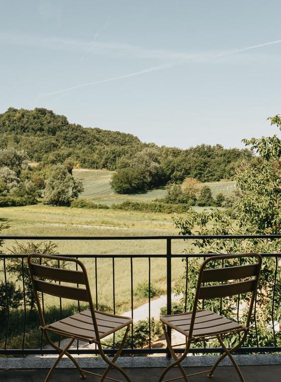 two chairs sitting on a balcony with a view of a field at Casa Praie in Casasco