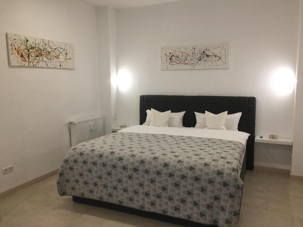 a bedroom with a bed with a black and white comforter at Exclusive Airport Apartment in Kelsterbach