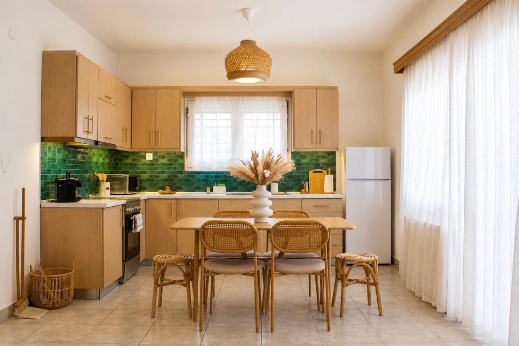 a kitchen with a table with chairs and a refrigerator at Dry martini in Myrina