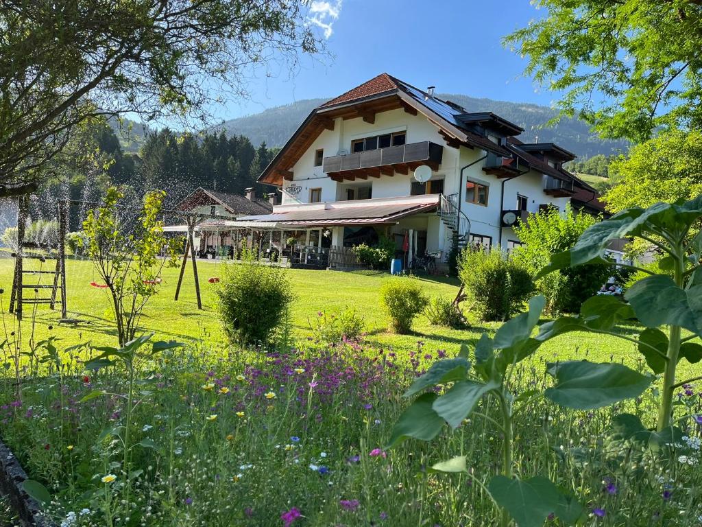 a house in a field with a garden at Frühstücks-Radpension Taurer-Thoman in Dellach im Drautal