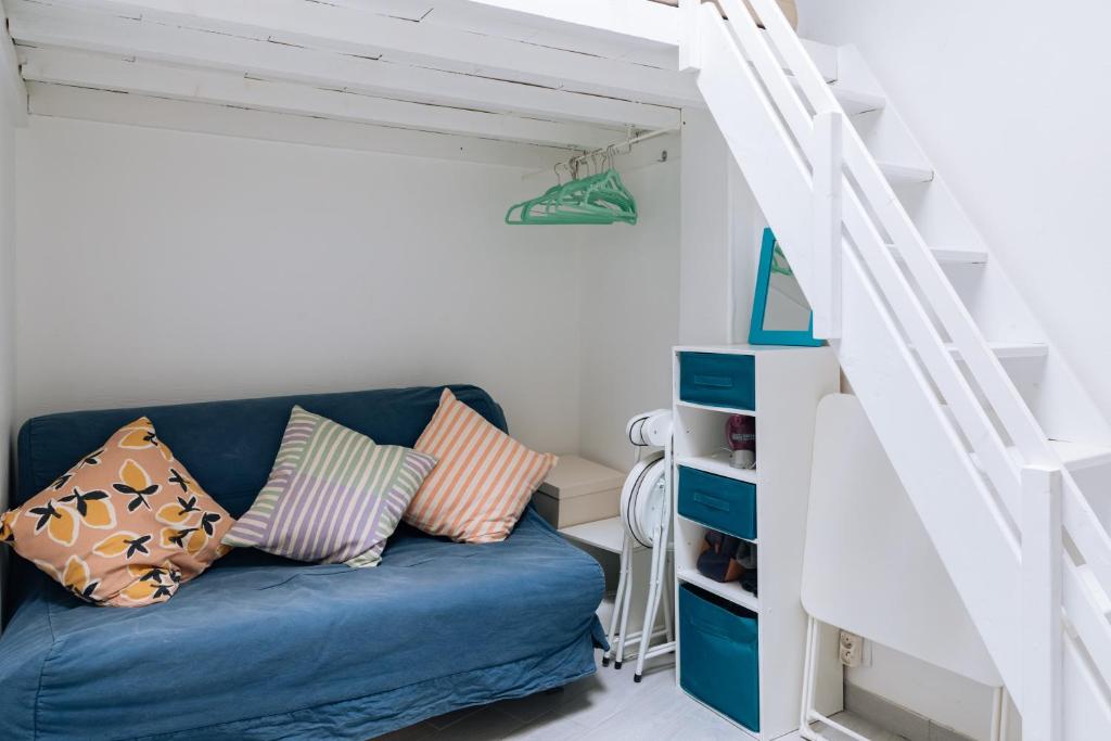 a blue couch in a living room with stairs at Chic Studio Apartment for 3 - La Villette! in Paris