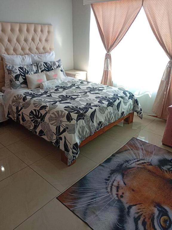 a bedroom with a bed with a black and white comforter at Uptown Inn GuestHouse in Parys