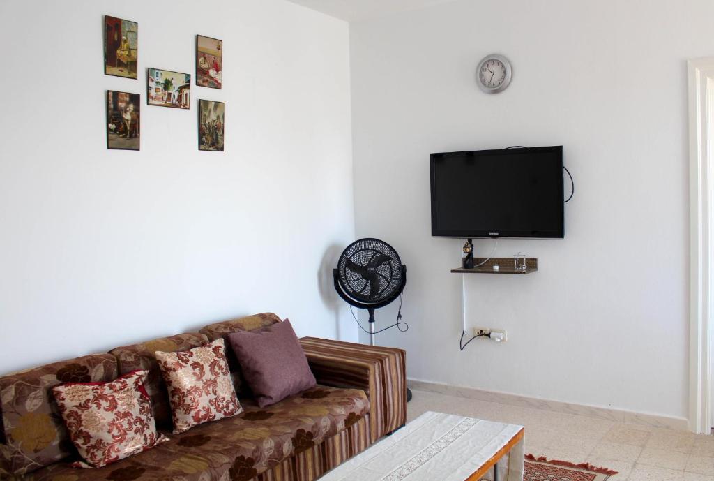 a living room with a couch and a flat screen tv at Résidence Chahed in Hammam Sousse