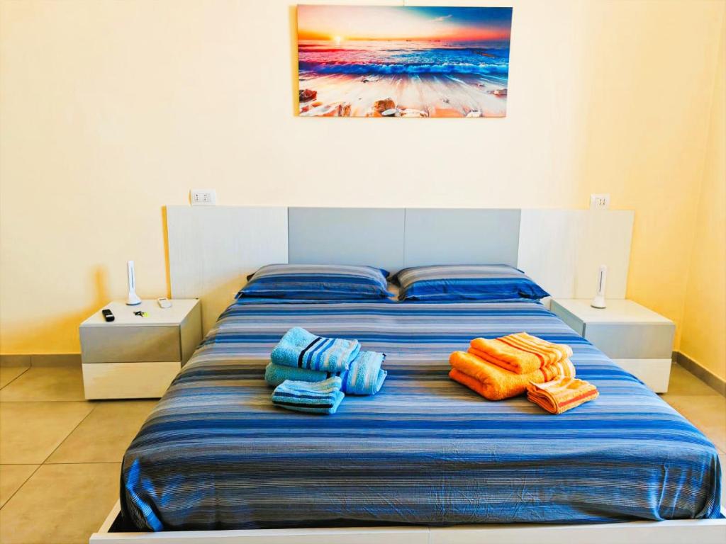 a bed with blue and orange towels on it at MS Sea Port Rooms in Ancona