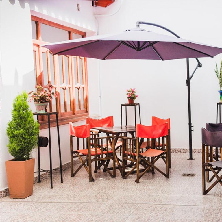 a table and chairs with an umbrella on a patio at Inti Masi in Salta