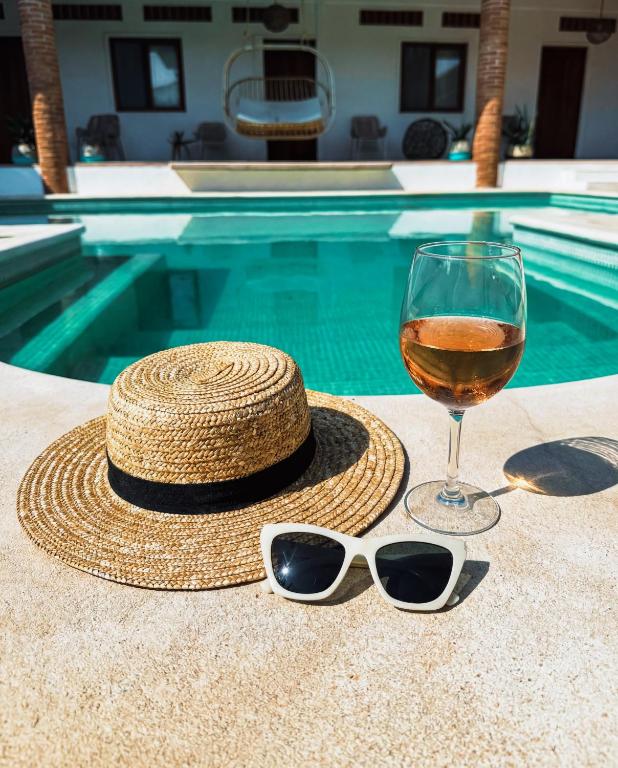 a straw hat and a glass of wine and a hat and sunglasses at Santuario San Agustín in Bajo de Arenal