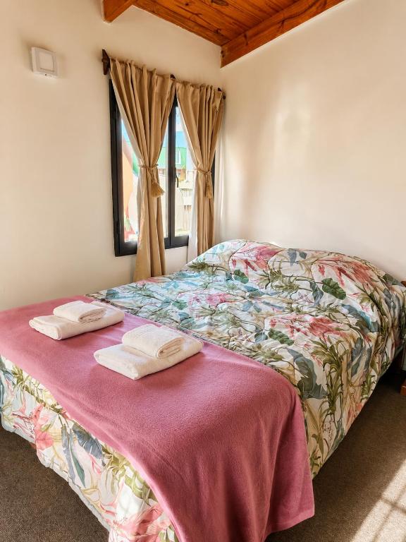 a bedroom with a bed with two towels on it at Miniloft Centrico in El Calafate