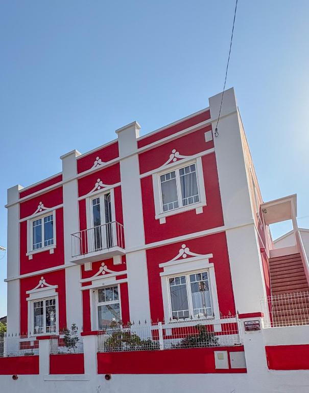 a red and white building with white windows at Palacete da Vermelha in Vermelho