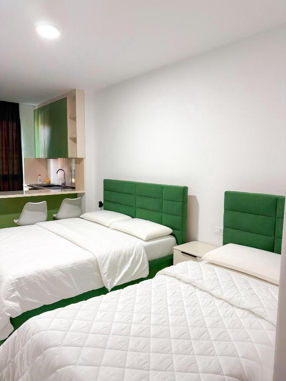 two beds in a room with green and white at Kurti Apartment in Golem