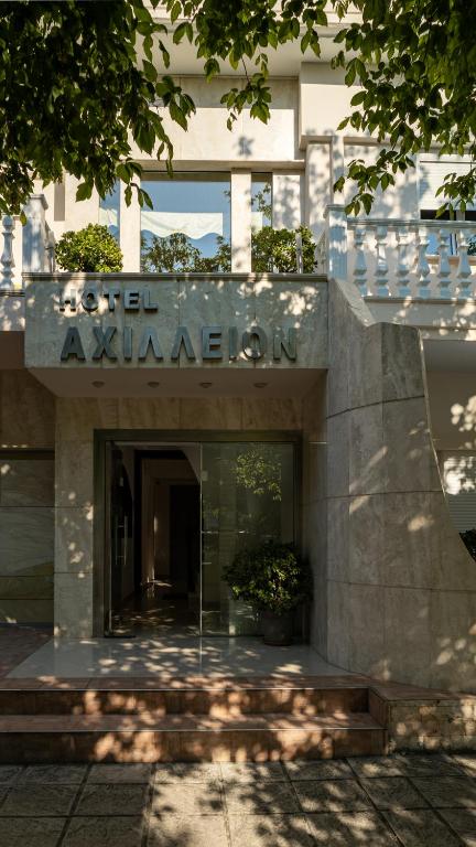 a building with a sign on the front of it at Achillion in Paralia Katerinis