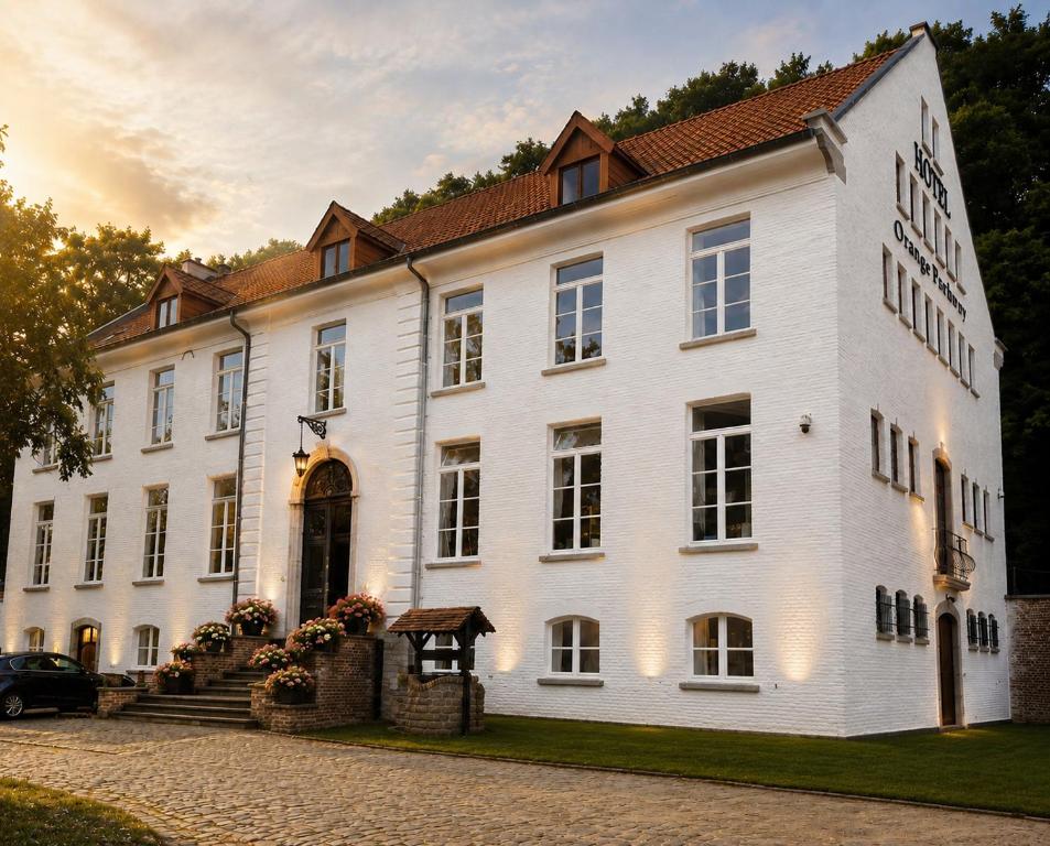 a large white building with a sign on it at Orange Parkway Hotel in Diest