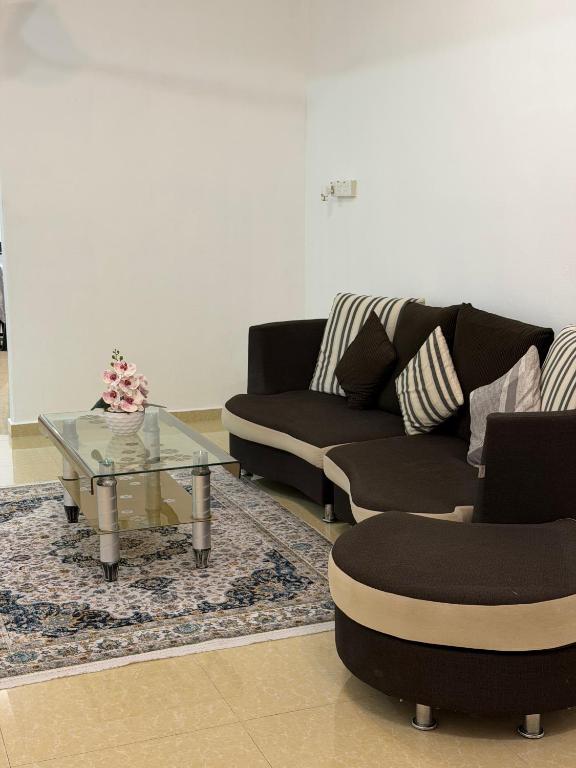 a living room with two couches and a glass table at Homestay Jerantut in Jerantut