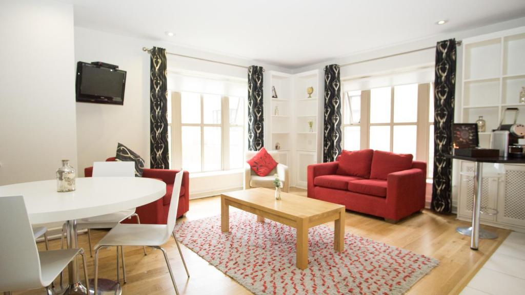 ein Wohnzimmer mit einem roten Sofa und einem Tisch in der Unterkunft Brennan Court Guest Accommodation in Limerick