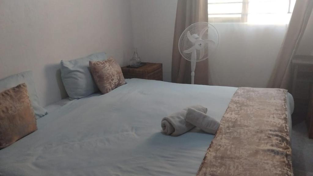 a bedroom with a bed with a stuffed animal on it at Queen Room self contained in Lusaka