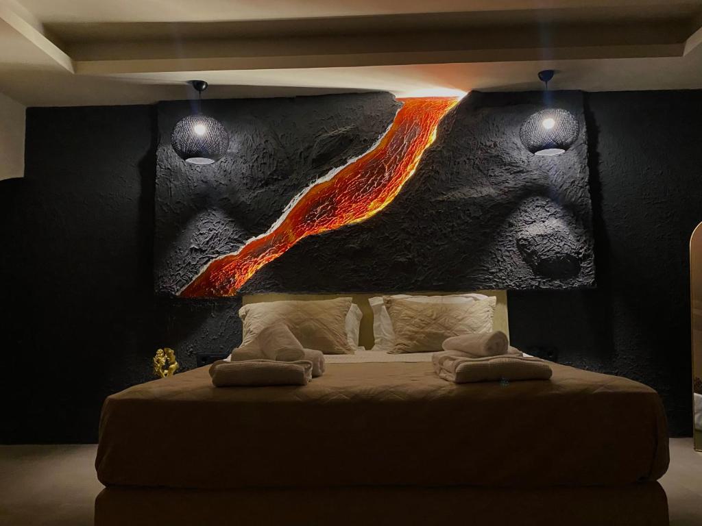 a bedroom with a bed with a painting on the wall at Bevimar Suites with Private Pool and Non Heated Jacuzzi in Santorini