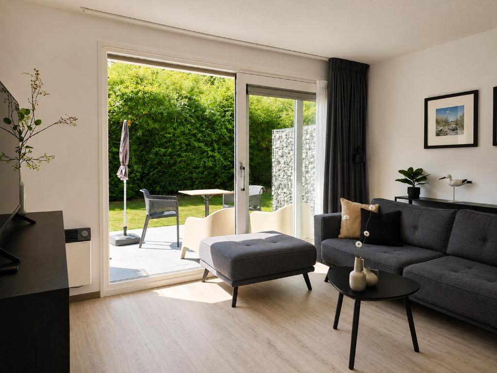 a living room with a couch and a table at Prins Prachtig Amelander Kaap 97 in Hollum