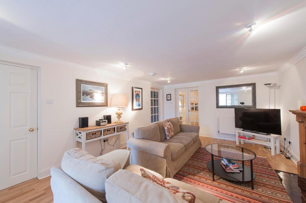ein Wohnzimmer mit 2 Sofas und einem Flachbild-TV in der Unterkunft Apartment Jamaica Street 7 in Edinburgh