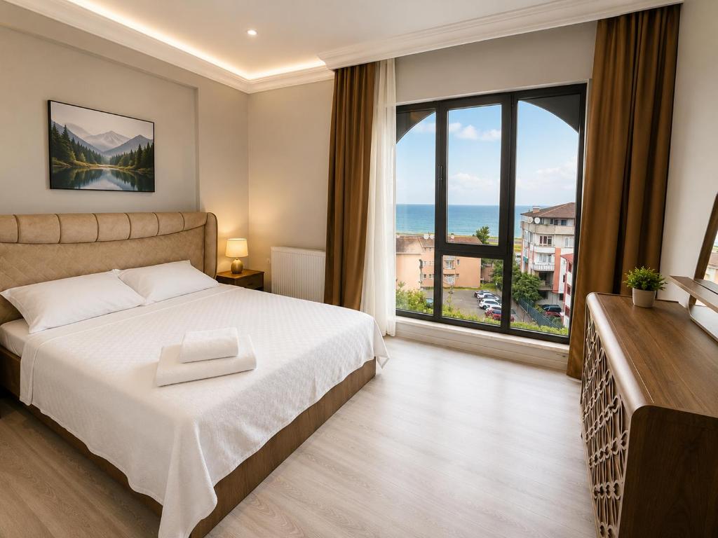 a bedroom with a bed and a large window at Pasha Residence in Trabzon